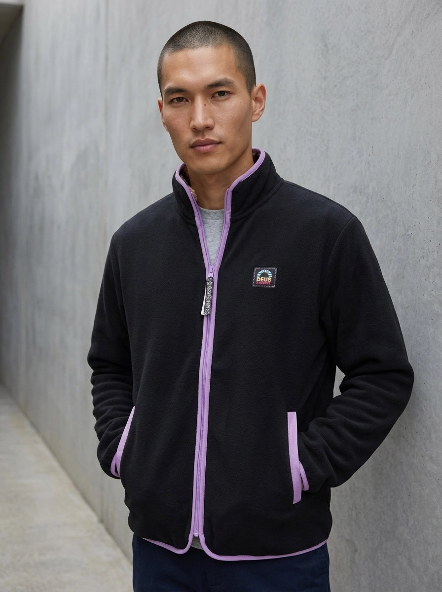 Deus Owen veste réversible portée côté noir uni, passepoil lilas, écusson Deus